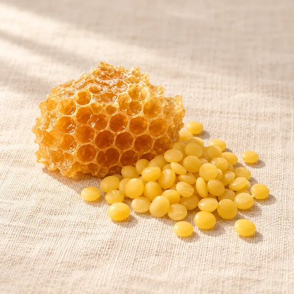 Honeycomb beside yellow beeswax pellets